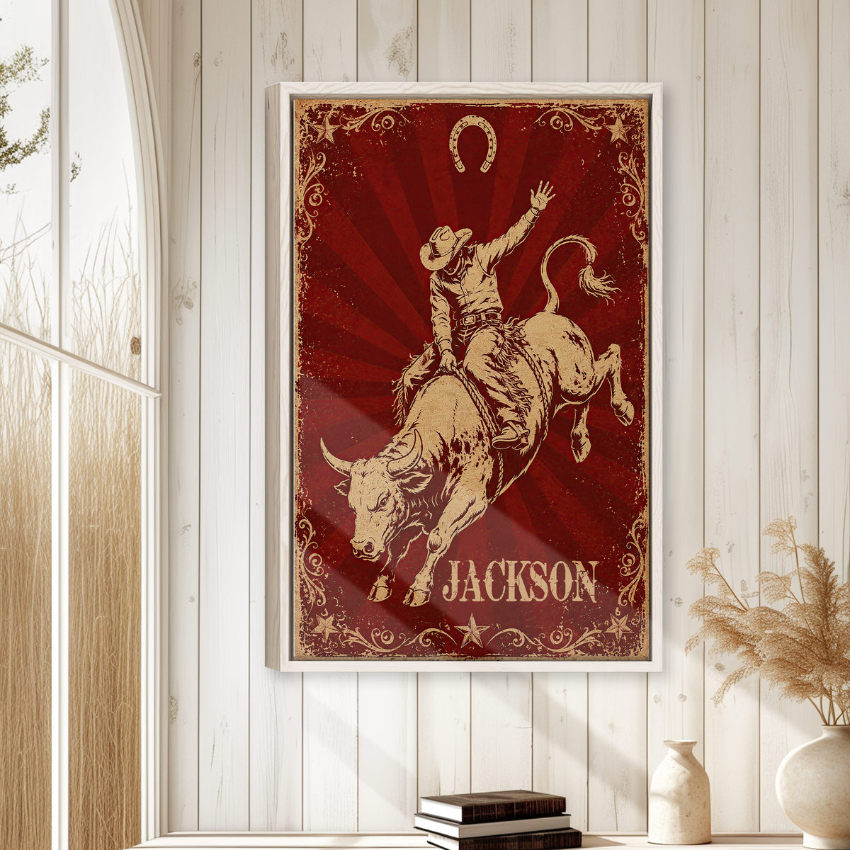 Framed cowboy bull riding wall art displayed on a white wood-paneled wall in a rustic home setting