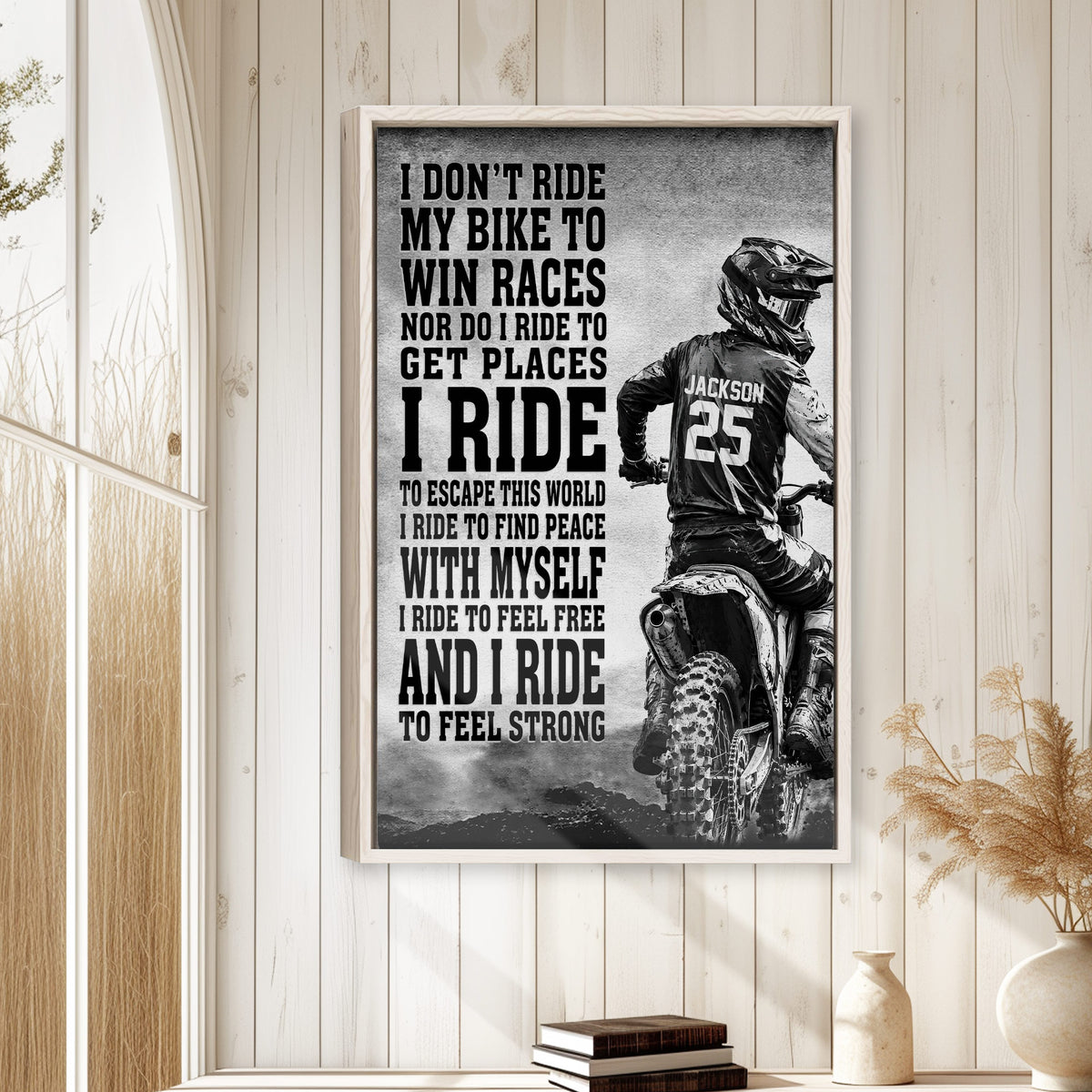 Framed motocross wall art displayed on a light wood-paneled wall in a bright home decor setting