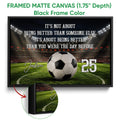 Black framed soccer canvas wall art with a stadium background, soccer ball, and green field