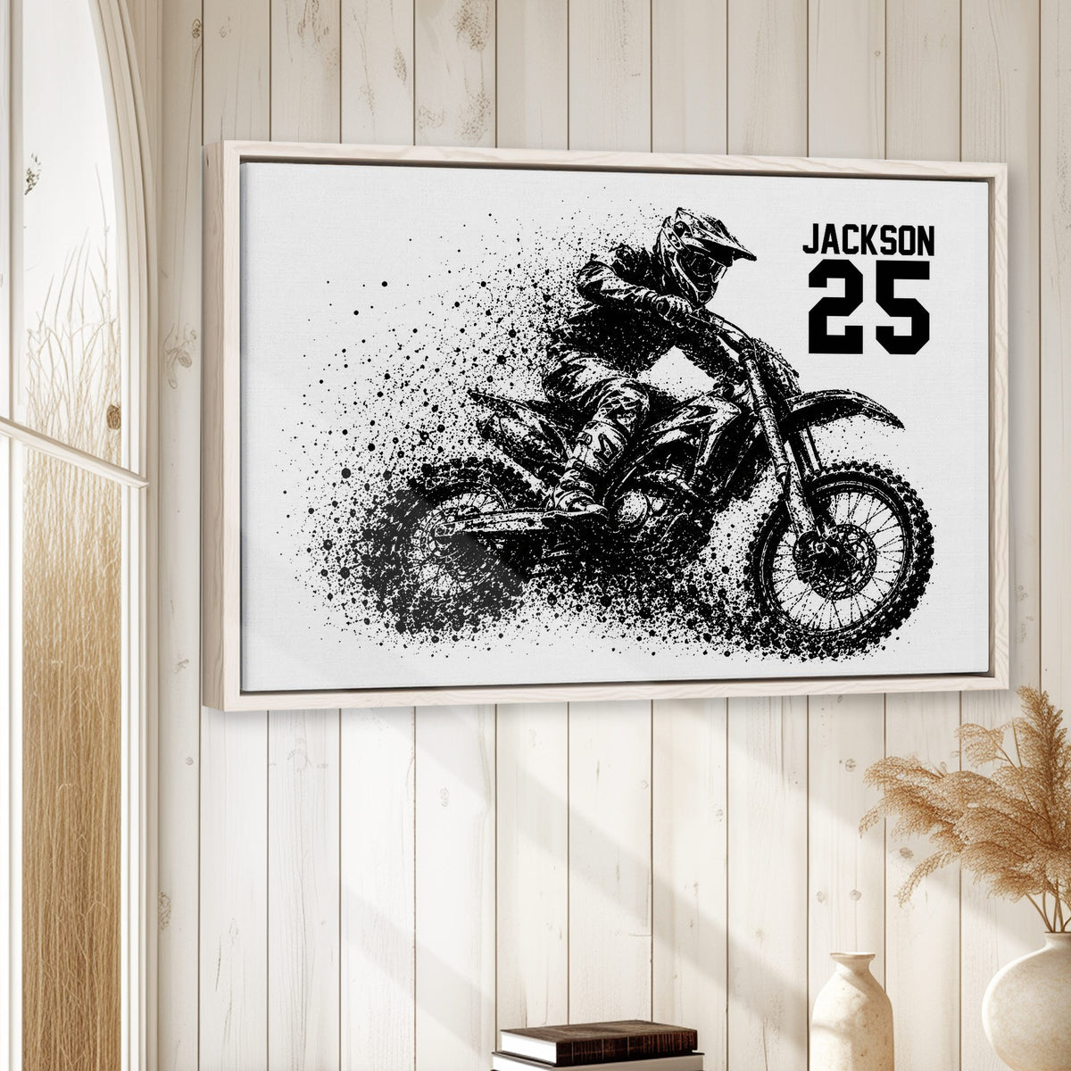 Motocross framed wall art displayed on a light wood-paneled wall in a relaxed home setting