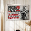 Framed motocross wall art displayed on a light wood wall in a relaxed home decor setting