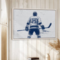 Hockey wall art displayed in a bright wood-paneled room with neutral decor and a natural wood frame