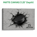Matte canvas hockey wall art showing a black puck breaking through a cracked surface