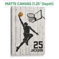 Matte canvas basketball wall art featuring a silhouetted player, orange ball and hoop on white wood
