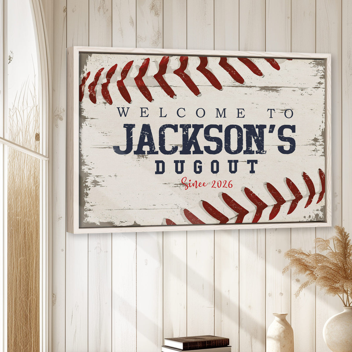 Framed baseball wall art displayed on a light wood-paneled wall in a rustic home setting
