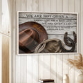 Framed cowboy wall art displayed on a white wood-paneled wall in a rustic home setting