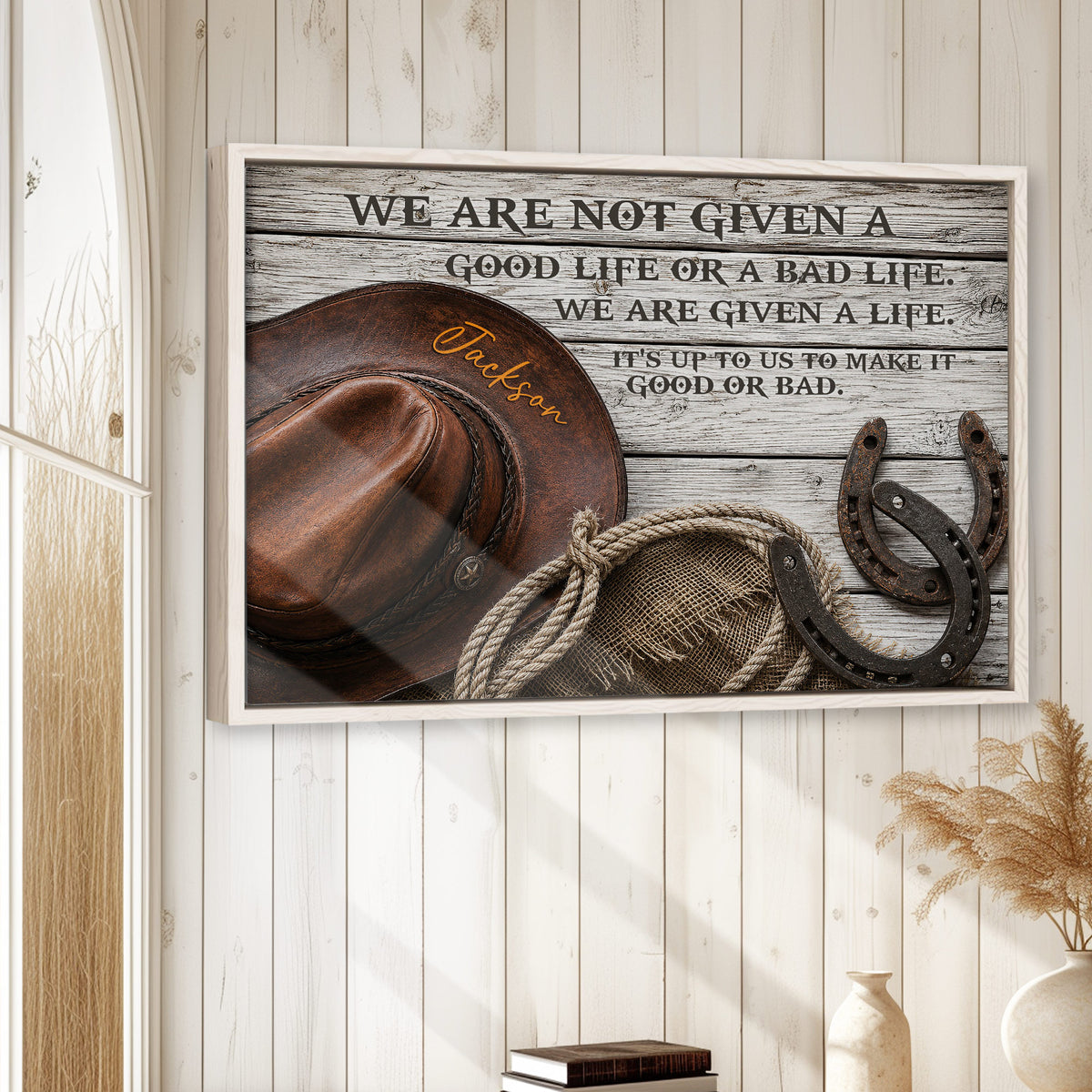 Framed cowboy wall art displayed on a white wood-paneled wall in a rustic home setting