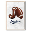 Framed football wall art featuring a brown football and horseshoe on a light textured background