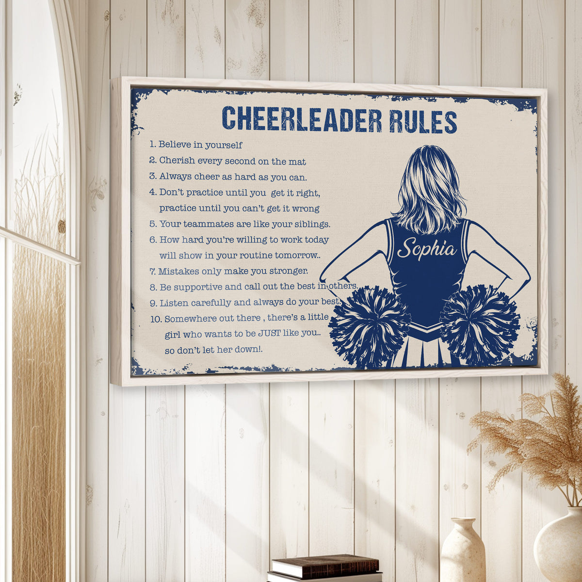 Cheerleading wall art displayed in a bright room with white wood paneling