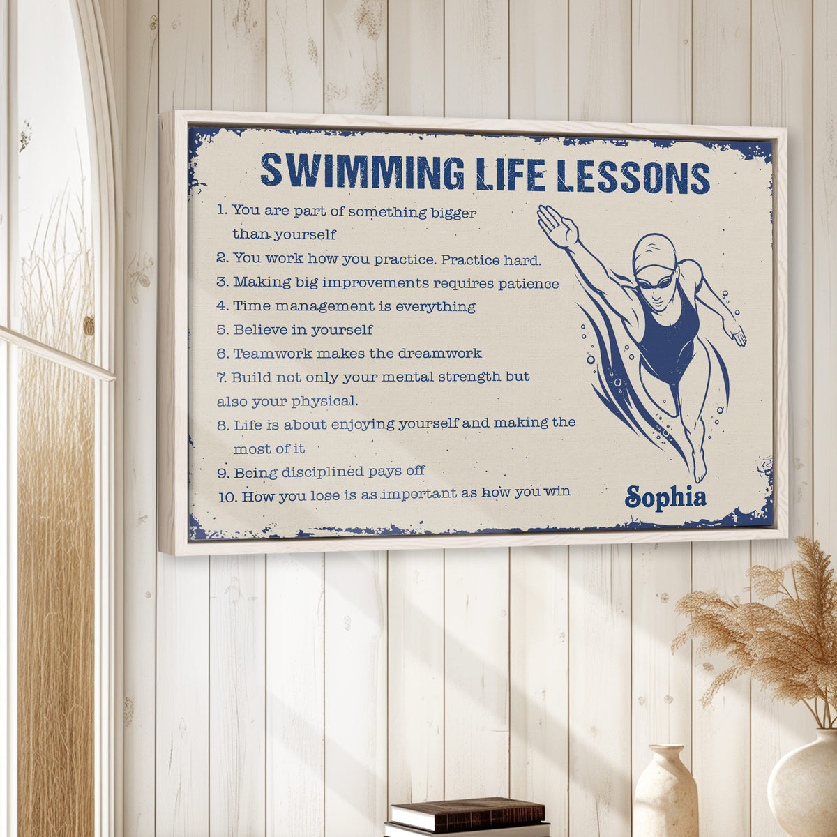 Framed swimming wall art displayed on a light wood-paneled wall in a calm neutral room