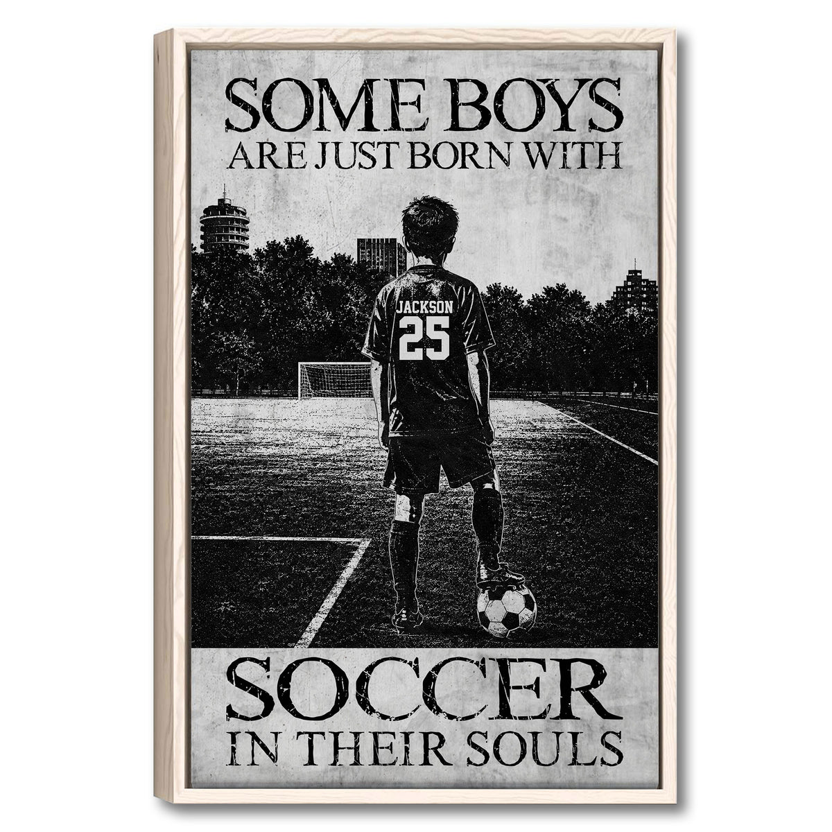 Framed soccer wall art showing a young player with a ball on an outdoor field in monochrome style