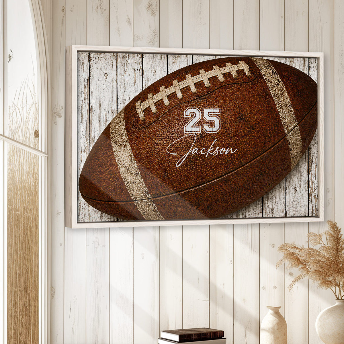 Framed football wall art displayed on a bright white wood wall in a relaxed home setting