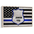 Framed police badge wall art with a blue line American flag design in black and gray