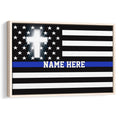 Framed police wall art featuring a thin blue line flag, stars, black and white stripes, and a glowing white cross