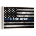 Framed police wall art featuring a distressed black and white flag with a blue line