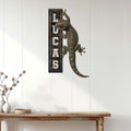 Realistic gecko metal sign displayed on a white paneled wall above a console table