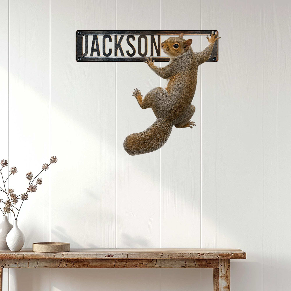 Squirrel wall sign displayed on a white paneled wall above a rustic console table