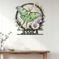 Green moth wall sign displayed on a bright paneled wall above a console table