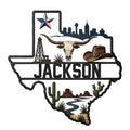 Texas-shaped metal sign with a longhorn skull, cowboy hat, oil derrick, skyline, star, cactus, and desert landscape