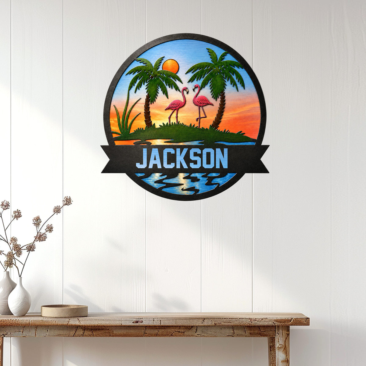 Flamingo metal wall decor displayed on a white paneled wall above a wooden console table