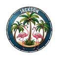 Round flamingo metal sign featuring two pink flamingos, palm trees, tropical foliage, and a dark blue border
