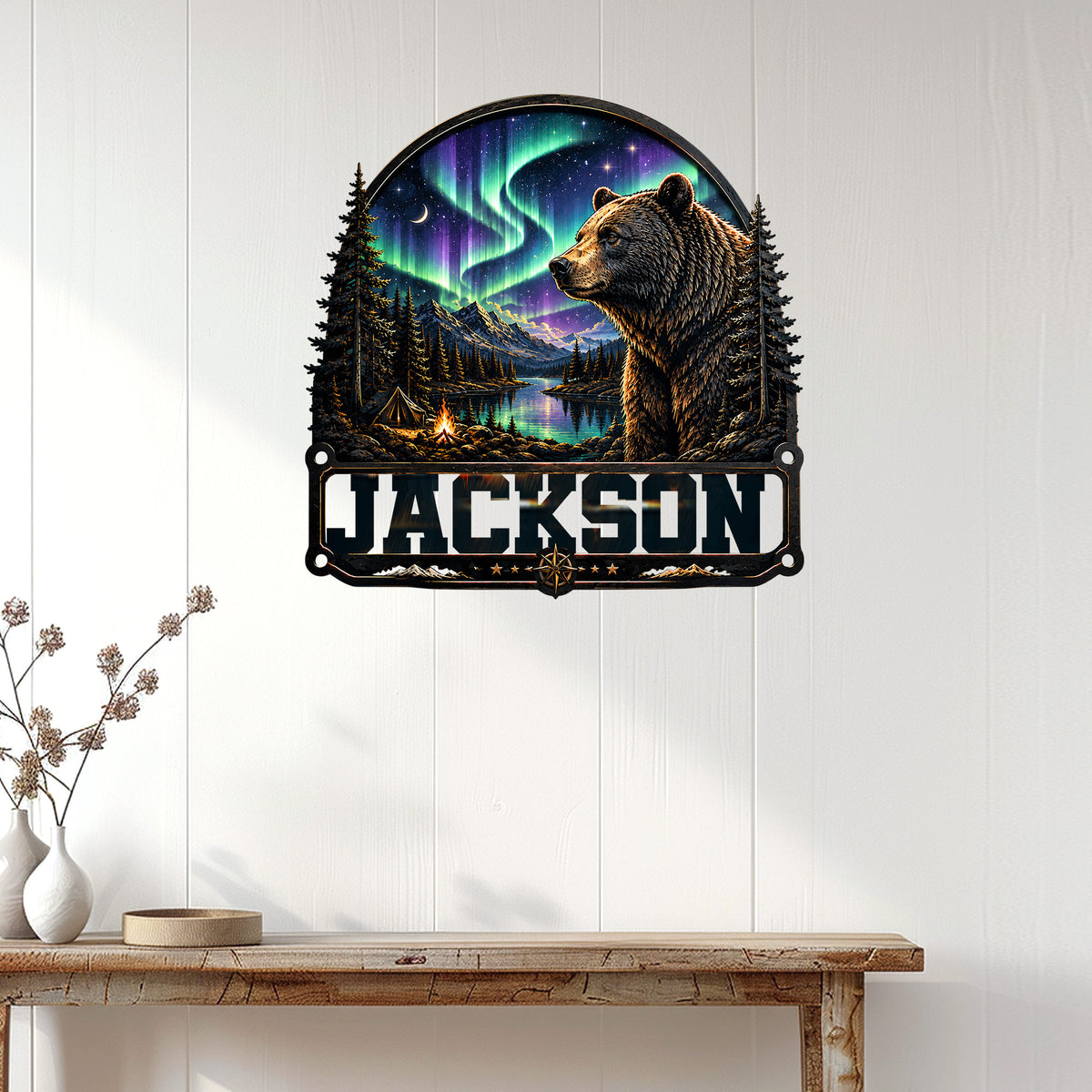 Bear wall sign displayed on white paneling above a console table in a nature-inspired home