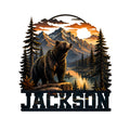 Custom bear metal sign featuring a black bear overlooking a mountain lake, pine forest, and sunset landscape