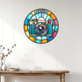 Stained-glass-style camera metal sign displayed on a light paneled wall above a console table