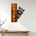 Raccoon wall sign displayed on a bright paneled wall above a rustic console table