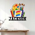 Artist wall sign displayed on a white paneled wall above a console table in a creative studio setting