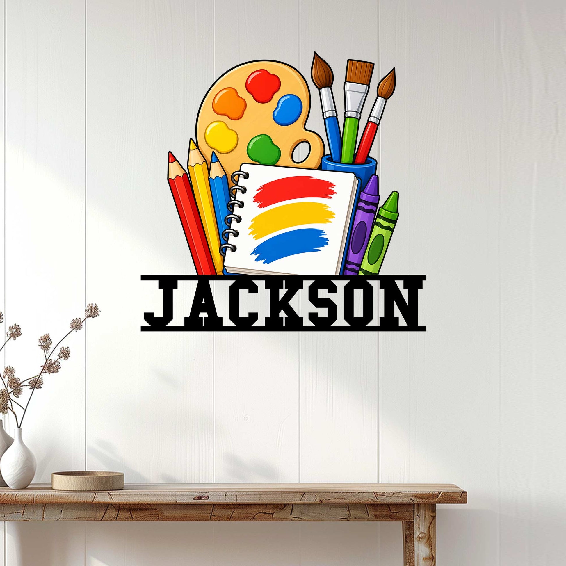 Artist wall sign displayed on a white paneled wall above a console table in a creative studio setting