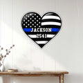 Thin blue line police heart sign displayed on a light wood-paneled wall