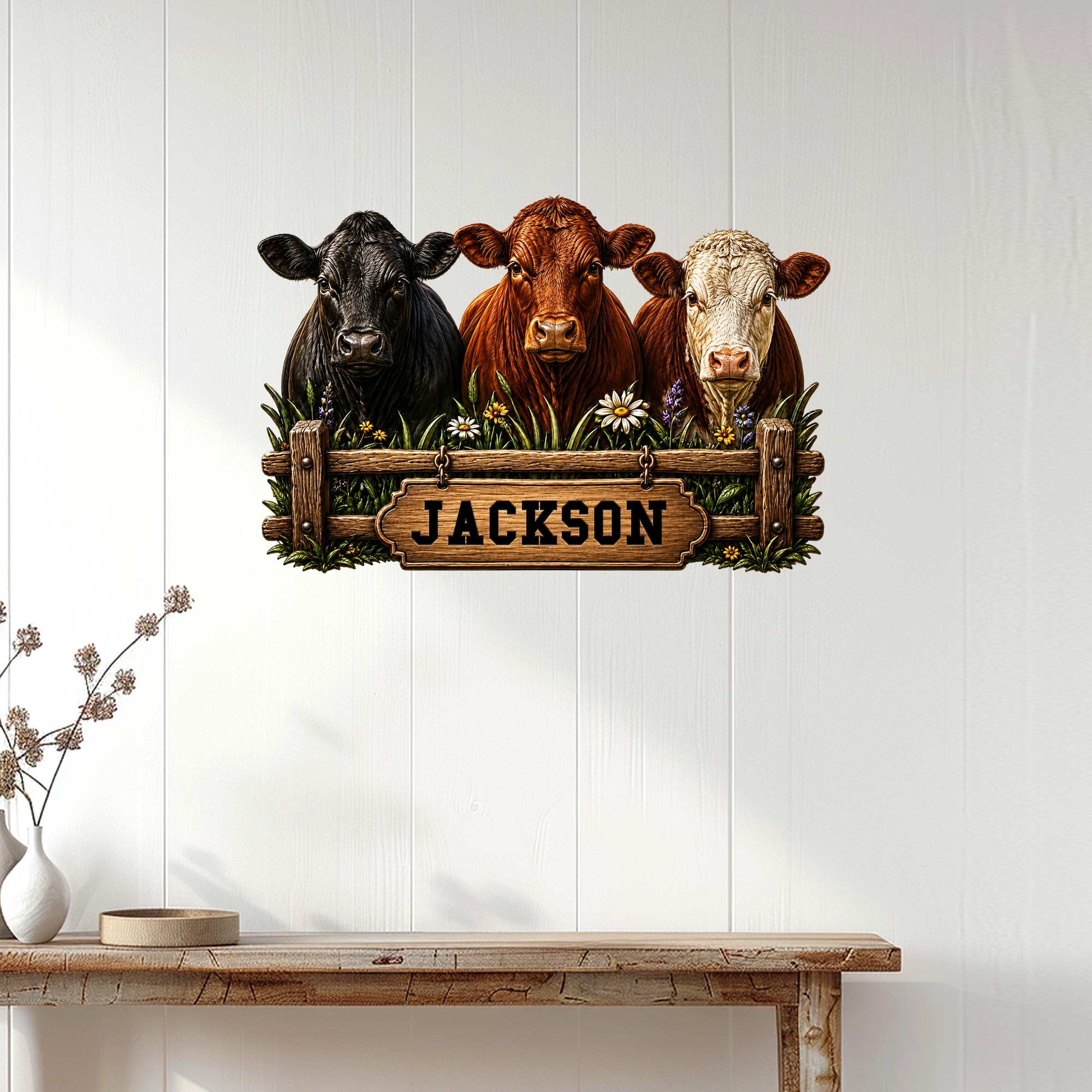 Rustic three-cow metal wall sign displayed on a light wood-paneled wall above a console table