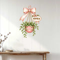 Hanging plant metal sign styled on a white wood wall above a console table for home garden decor