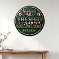 Floral She Shed metal sign displayed on a white paneled wall above a rustic console table