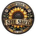 Close-up of a custom She Shed metal sign with a golden sunflower, botanical accents, and ornate banner