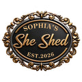 Close-up of an ornate black and gold She Shed metal sign with elegant scrollwork