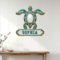 Ornate turquoise turtle wall sign displayed on a white paneled entryway above a wood console