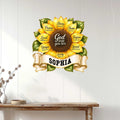 Christian sunflower wall sign displayed on a light wood-paneled wall above a console table