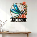Dragonfly metal wall sign displayed on a light wood-paneled wall above a console table