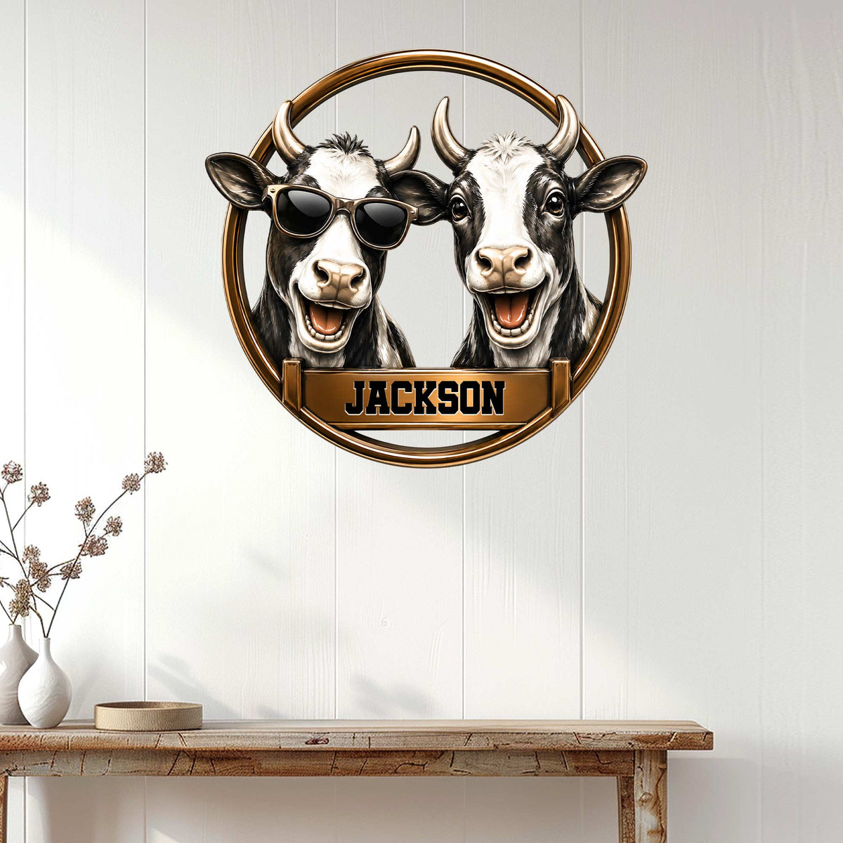 Cow wall decor displayed above a console table, featuring two playful black-and-white cows in a circular frame