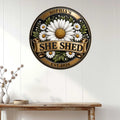 Floral She Shed wall sign displayed on a white paneled wall above a rustic console table