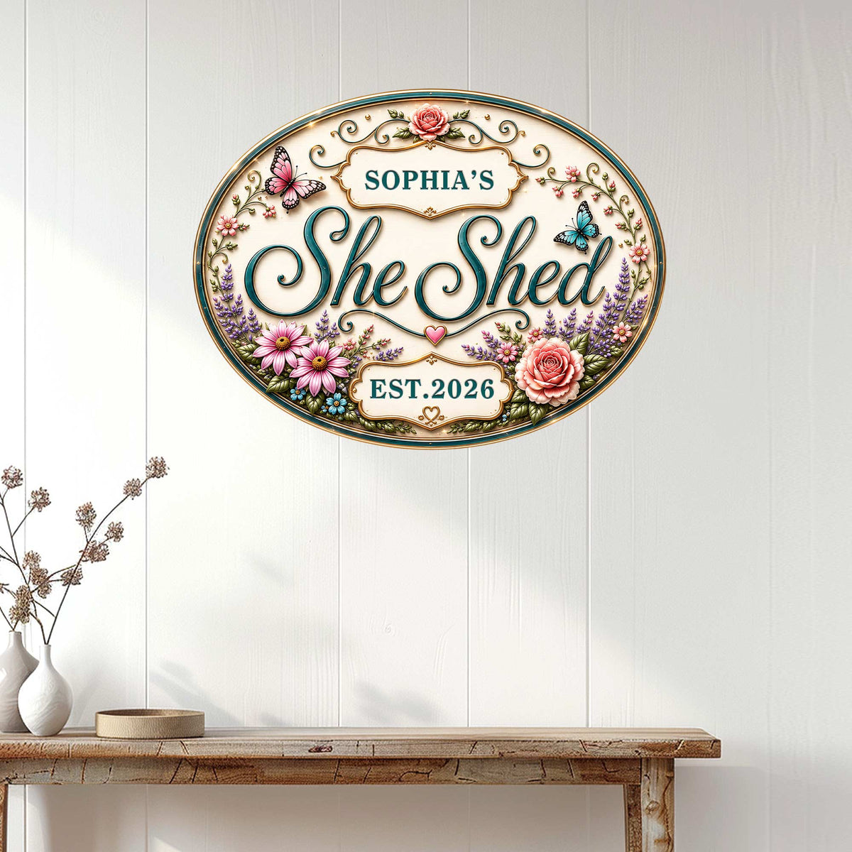 Floral She Shed metal sign displayed on a white paneled wall above a rustic console table