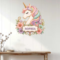 Floral unicorn metal wall sign displayed on a light wood wall above a console table