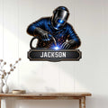 Welder wall sign displayed on a light paneled wall above a console table in a bright home interior