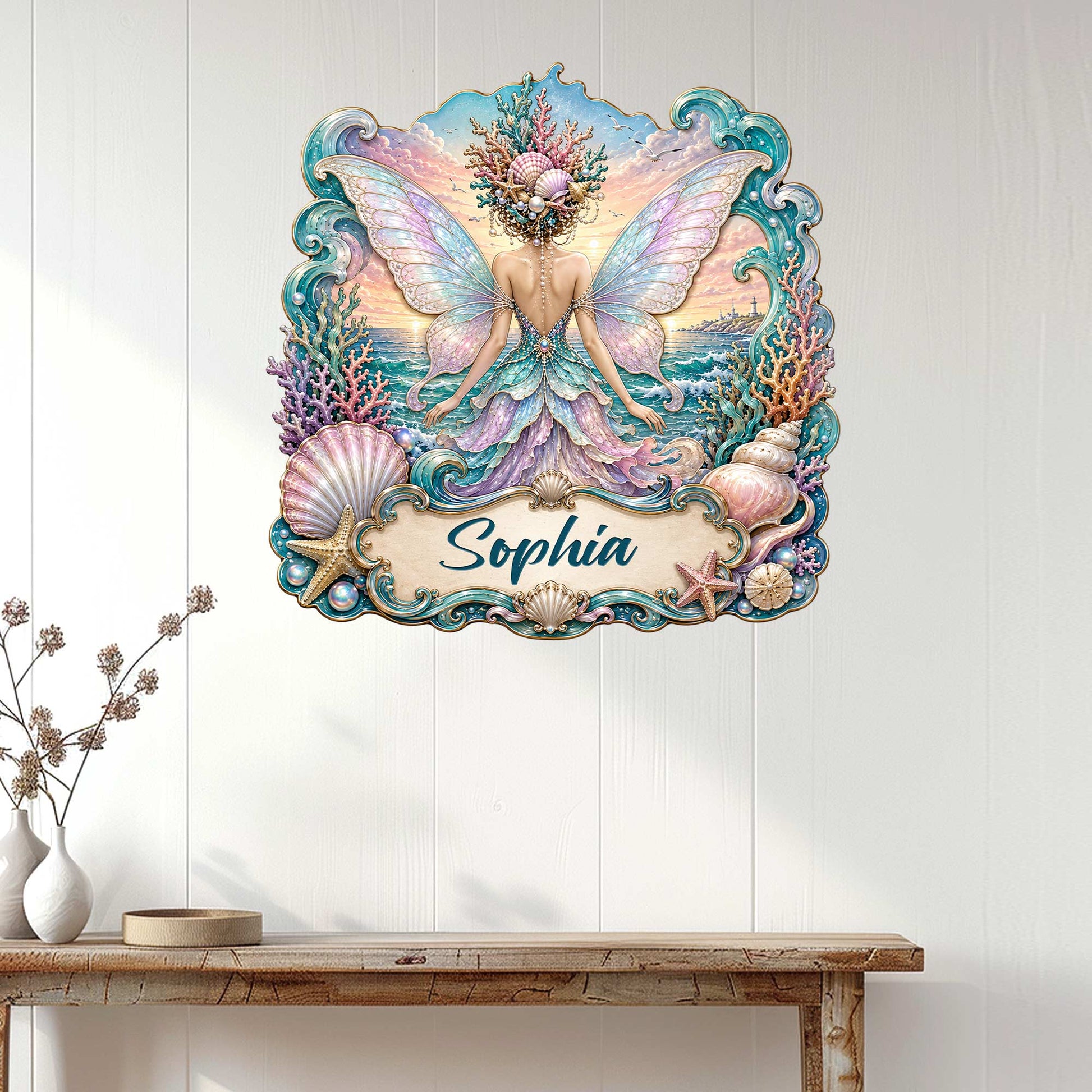 Ocean fairy wall decor displayed on a light wood wall, featuring pastel wings, seashells, coral, and coastal waves