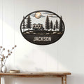 RV camping wall decor displayed on a white paneled wall, featuring a camper surrounded by pine trees at night