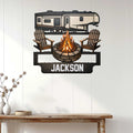 Camping wall decor displayed on a white paneled wall, featuring an RV, campfire, and Adirondack chairs