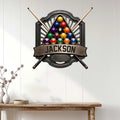 Custom pool room wall sign displayed on a light paneled wall above a rustic console table