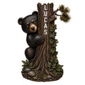 Detailed black bear cub peeking around a tree in a forest-inspired metal sign design